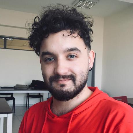 Birkan Kader in a red hoodie, smiling, in an office.